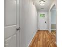 Inviting hallway with wood flooring, featuring an entry door with glass panes and an arched doorway at 169 Clearwater Harbor Hbr, Sanford, NC 27332