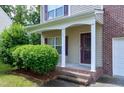 Inviting covered porch with white columns, brick steps, and manicured landscaping for enhanced curb appeal at 18 Gwendolyn Cir, Durham, NC 27703