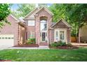 Charming two-story brick home featuring a well-manicured lawn and an inviting entryway at 216 Lewey Brook Dr, Cary, NC 27519