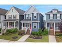 Attractive two-story blue home with a front porch, flanked by well-manicured landscaping and neighboring houses at 224 Daniel Ridge Rd, Wendell, NC 27591