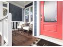 Cozy front porch featuring comfortable seating, a bright red door, and a glimpse of the home's address at 224 Daniel Ridge Rd, Wendell, NC 27591