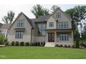 Attractive two-story home with manicured lawn, light exterior and dark window trim at 2577 Silas Peak Ln, Apex, NC 27523