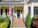 Charming front entrance with brick steps, American flag, and beautiful landscaping at 2645 Ridgewell Ct, Raleigh, NC 27613
