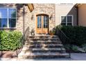 Close-up of the front door with stone steps, metal railings, and lantern-style sconces at 268 The Preserve Trl, Chapel Hill, NC 27517