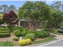 Charming brick home with lush landscaping, mature trees, and a well-maintained front yard at 4109 City Of Oaks Wynd, Raleigh, NC 27612