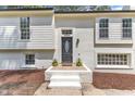 Close up of a lovely home's entrance, showcasing a decorative front door, white brick, and trimmed plants at 4504 Ryegate Dr, Raleigh, NC 27604