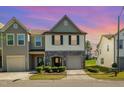 Charming two-story townhouse with a stone facade and attached garage during sunset at 5031 Eagle Stone Ln, Raleigh, NC 27610