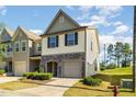 Charming townhome featuring a stone front, attached garage, and manicured landscaping at 5031 Eagle Stone Ln, Raleigh, NC 27610