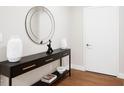 Stylish entryway featuring a black console table, modern mirror, decorative vases, and hardwood floors at 515 N Churton St # Ste 201, Hillsborough, NC 27278