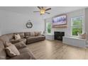 Bright living room with modern floors, shiplap accent wall, cozy fireplace, and large windows at 55 Prospectus Ln, Franklinton, NC 27525