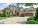Charming brick home boasts a stone accented entrance, a well-maintained lawn, and a circular driveway for easy access at 603 Hawks Ridge Ct, Apex, NC 27539