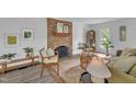 Bright living room featuring a brick fireplace, neutral decor, and ample natural light at 608 Cross Timbers Dr, Durham, NC 27713