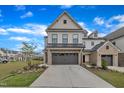 Two-story home with brick and siding, showcasing a well-manicured lawn and an attached two car garage at 81 Paperwhite Pl # 213, Clayton, NC 27527