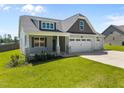Inviting home featuring a welcoming front porch, attractive landscaping, and an attached three-car garage at 834 Mamie Upchurch Rd, Lillington, NC 27546