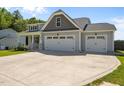 Exterior view showcasing a home's three-car garage and well-maintained landscaping at 834 Mamie Upchurch Rd, Lillington, NC 27546