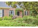 Charming brick home featuring an arched entrance with lush greenery and manicured landscaping at 8605 Stanton Pl, Raleigh, NC 27615