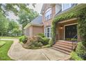 Elegant brick home with an inviting entrance adorned with climbing vines and brick steps at 8605 Stanton Pl, Raleigh, NC 27615