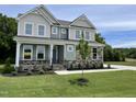 Charming two-story home featuring a landscaped yard, stone accents, and a welcoming front porch at 87 Browning Mill Dr, Wendell, NC 27591