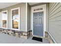 Close-up of a stylish front door with stone accents and ample natural light from the adjacent windows at 87 Browning Mill Dr, Wendell, NC 27591