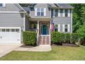 Close-up of the front entrance showcasing the blue door, fresh landscaping, and inviting staircase at 9300 Glendora Ct, Garner, NC 27529
