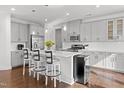 Modern kitchen boasts an island with seating, stainless steel appliances, and white subway tile backsplash at 931 Haybeck Ln, Apex, NC 27523