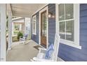 Inviting front porch featuring rocking chairs and a stylish wood door at 941 W Club Blvd, Durham, NC 27701