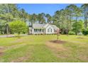 Beautifully landscaped front yard with a charming single-story home nestled amongst mature trees at 110 Phyllis Dr, Benson, NC 27504