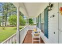 Inviting front porch with a cozy bench, decorative pillows, and charming curb appeal at 110 Phyllis Dr, Benson, NC 27504