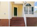 Charming front entrance with brick steps, green door, and arched window above white-framed window, adding curb appeal at 1211 Azalea Dr, Zebulon, NC 27597