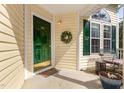 Inviting front porch with a dark green front door, wreath, and seating area, ideal for relaxing at 1211 Azalea Dr, Zebulon, NC 27597