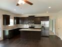 Modern kitchen with stainless steel appliances, granite countertops, dark wood cabinets and an island at 1249 Turkey Trot Rd, Wendell, NC 27591