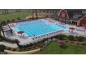 Resort-style community pool with ample lounge seating, a clubhouse, and lush landscaping at 13 Cozy Hvn, Fuquay Varina, NC 27526