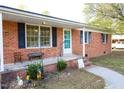 Charming brick home with a welcoming front porch, shutters, and well-manicured landscaping at 130 Church Circle Ln, Bunnlevel, NC 28323