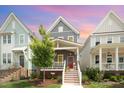 Charming two-story home showcasing a red door, inviting front porch and well-maintained lawn and landscaping at 1515 Millrock Trl, Wendell, NC 27591