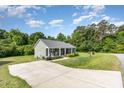 Well-manicured lawn and long driveway lead to this cozy one-story home with inviting front porch at 18 Hunter Fox Trl, Angier, NC 27501