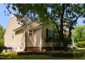 The home's exterior shows well-maintained siding, complemented by dark shutters and the surrounding greenery at 200 Steeple Rd, Holly Springs, NC 27540
