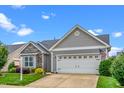 Charming home featuring a two-car garage, stone accents, manicured lawn, and mature landscaping, offering great curb appeal at 2033 Buck Corner Ln, Fuquay Varina, NC 27526