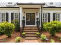 Close-up of the front entrance with brick steps, double doors, and decorative plants at 2190 Keith Hills Rd, Lillington, NC 27546