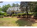 Charming white home with black shutters, dormer windows, and lush landscaping at 2190 Keith Hills Rd, Lillington, NC 27546