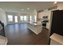 Bright open-concept kitchen/living area with hardwood floors, a center island, and modern appliances at 239 Paramount Dr, Smithfield, NC 27577