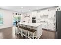 Bright kitchen featuring white cabinets, quartz countertops, a center island with seating, and stainless steel appliances at 2521 Georgianna Dr, Wake Forest, NC 27587
