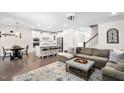 Open-concept living space with kitchen, comfortable seating, modern decor, and a large decorative rug at 2521 Georgianna Dr, Wake Forest, NC 27587