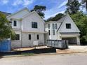 Exterior view of new construction home with white paint, black framed windows and open garage at 323 Hudson St, Raleigh, NC 27608