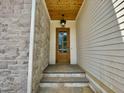 Close up of front door with wood ceiling and gray stone wall feature at 323 Hudson St, Raleigh, NC 27608