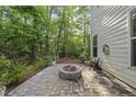 Backyard stone patio with fire pit, perfect for outdoor entertaining, surrounded by mature trees at 359 Ashton Ridge Ln, Cary, NC 27513