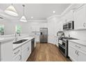 Bright kitchen features white cabinets, stainless steel appliances, and hardwood floors at 359 Ashton Ridge Ln, Cary, NC 27513