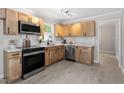 Bright kitchen features stainless steel appliances, wood cabinets, and marble-look countertops at 3700 Summer Pl, Raleigh, NC 27604