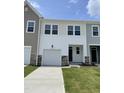 Well-maintained townhouse with white siding, a front-facing garage, and a small green lawn at 377 Thompson Overlook Way, Smithfield, NC 27577