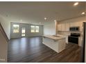 Open-concept living room with white cabinets, stainless steel appliances, and island at 381 Thompson Overlook Way, Smithfield, NC 27577