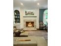 Cozy living room featuring a marble fireplace and an adjacent built-in bookcase at 404 Versailles Dr, Cary, NC 27511